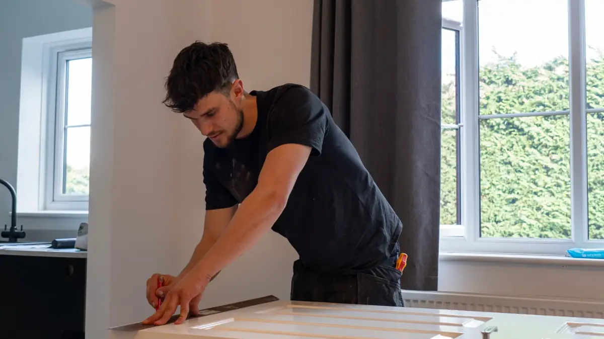 Marking a white panel door for trimming to clear new carpet in Warwickshire